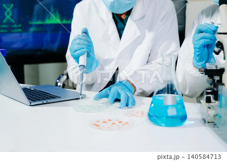 Scientists performing DNA genome analysis using digital tablet interface in biotechnology laboratory for medical research, genetics, pharmaceutical innovation and AI diagnostics. Scientists performing DNA genome analysis using digital tablet interface in biotechnology laboratory for medical research, genetics, pharmaceutical innovation and AI diagnostics. 140584713