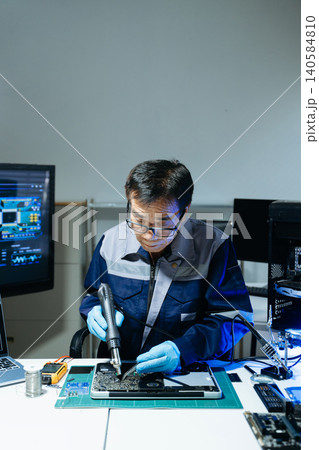 Technician performing PCB soldering and diagnostics with multimeter in electronics lab, showcasing hardware engineering Technician performing PCB soldering and diagnostics with multimeter in electronics lab, showcasing hardware engineering 140584810