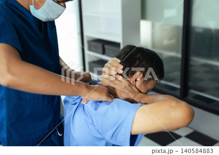 Physical therapist helping patient with shoulder rehabilitation exercise in clinic. Healthcare treatment, physiotherapy recovery, injury therapy 140584883