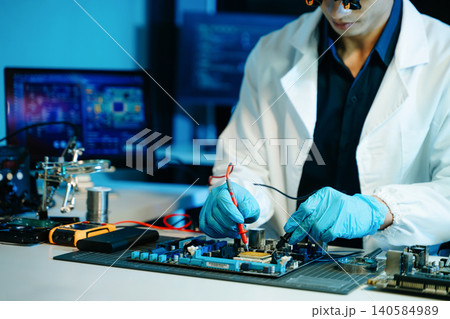 Technician testing computer motherboard with multimeter in a high-tech electronics lab, analyzing hardware diagnostics, cybersecurity systems 140584989