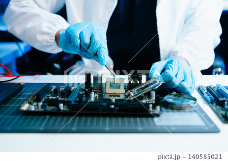 The technician is putting the CPU on the socket of the computer motherboard. electronic engineering electronic repair, electronics measuring and testing, repair The technician is putting the CPU on the socket of the computer motherboard. electronic engineering electronic repair, electronics measuring and testing, repair 140585021