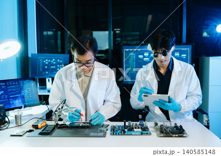 Engineers repairing computer hardware and analyzing data storage systems in a high-tech lab with cybersecurity monitoring, diagnostics, and digital technology 140585148
