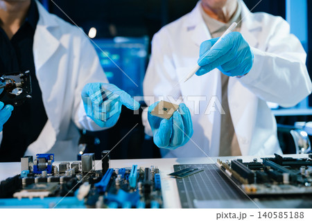 The technician is putting the CPU on the socket of the computer motherboard. electronic engineering electronic repair, electronics measuring The technician is putting the CPU on the socket of the computer motherboard. electronic engineering electronic repair, electronics measuring 140585188