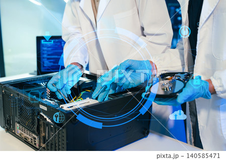 Engineers repairing computer hardware and hard drive in a technology lab. Concept of data storage, cybersecurity, digital infrastructure, electronics maintenance Engineers repairing computer hardware and hard drive in a technology lab. Concept of data storage, cybersecurity, digital infrastructure, electronics maintenance 140585471