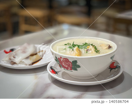 Traditional congee with rice noodle rolls and chicken, a comforting Asian breakfast Traditional congee with rice noodle rolls and chicken, a comforting Asian breakfast 140586704