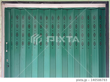 Vibrant vintage Hong Kong traditional green metal door with intricate design patterns and texture 140586783