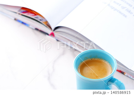 ページを開いた本(洋書)とコーヒーの入ったコーヒーカップで、コーヒーを飲みながら読書を楽しむイメージ ページを開いた本(洋書)とコーヒーの入ったコーヒーカップで、コーヒーを飲みながら読書を楽しむイメージ 140586915