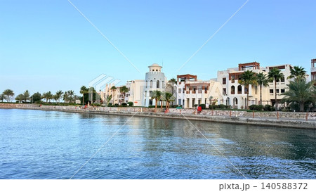 Mediterranean-style waterfront villas along calm blue harbor Mediterranean-style waterfront villas along calm blue harbor 140588372