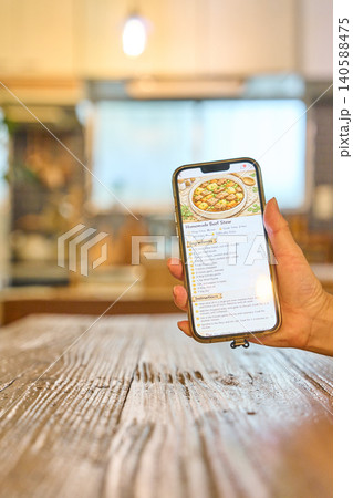 スマートフォンに表示されたレシピを見る手元 スマートフォンに表示されたレシピを見る手元 140588475