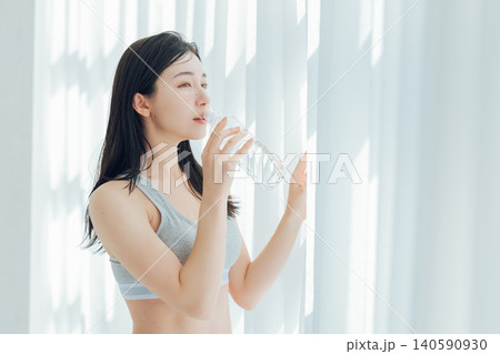 窓際で水を飲む女性 140590930