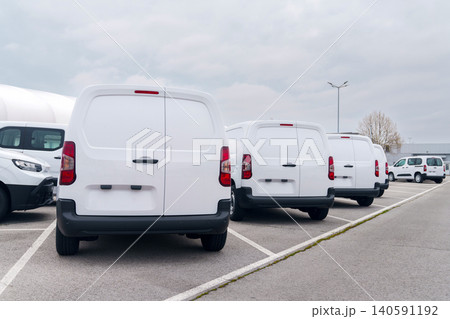 White delivery vans are parked in rows. Commercial fleet of vehicles White delivery vans are parked in rows. Commercial fleet of vehicles 140591192