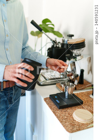 Man brewing espresso at home using a manual lever coffee machine. Man brewing espresso at home using a manual lever coffee machine. 140591231