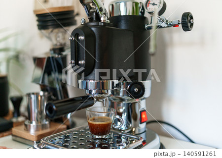 Home barista corner with a manual lever espresso machine and a single dose coffee grinder. Home barista corner with a manual lever espresso machine and a single dose coffee grinder. 140591261