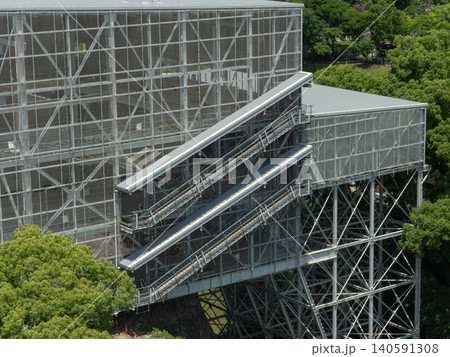 Large metal frame architectural construction with stairs and platforms outdoor in a park. 140591308