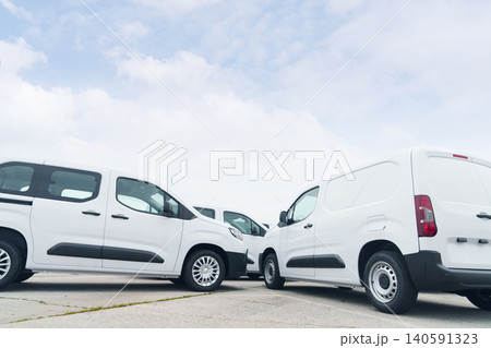 White delivery vans are parked in rows. Commercial fleet of vehicles. White delivery vans are parked in rows. Commercial fleet of vehicles. 140591323