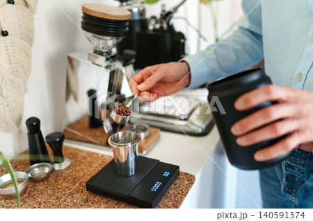 Man brewing espresso at home using a manual lever coffee machine. 140591374
