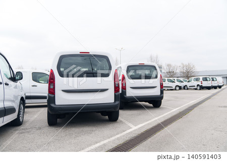 White delivery vans are parked in rows. Commercial fleet of vehicles.. 140591403