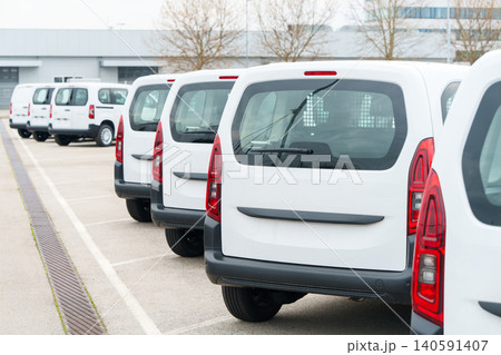 White delivery vans are parked in rows. Commercial fleet of vehicles White delivery vans are parked in rows. Commercial fleet of vehicles 140591407