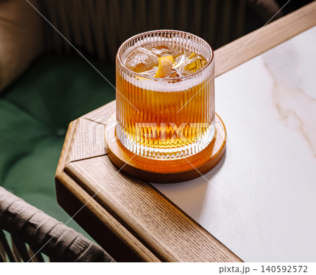 Old fashioned cocktail with orange peel and ice on table 140592572