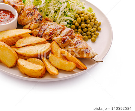 Grilled chicken skewer meal with potato wedges 140592584