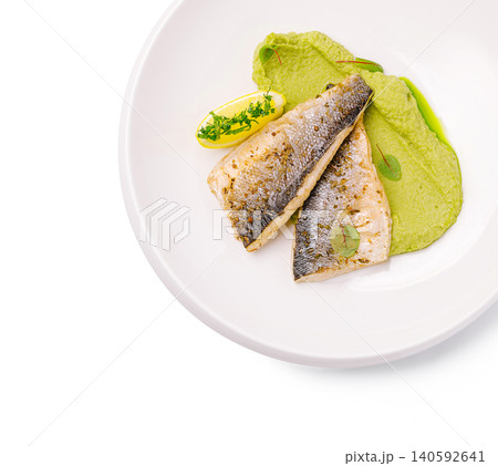 Grilled fish fillets with pea puree and lemon on plate Grilled fish fillets with pea puree and lemon on plate 140592641