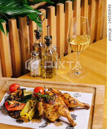 Grilled spatchcock chicken with roasted vegetables and white wine Grilled spatchcock chicken with roasted vegetables and white wine 140592648