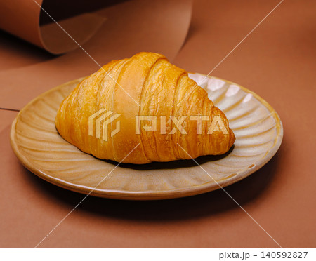 Golden croissant pastry serving on ceramic plate Golden croissant pastry serving on ceramic plate 140592827