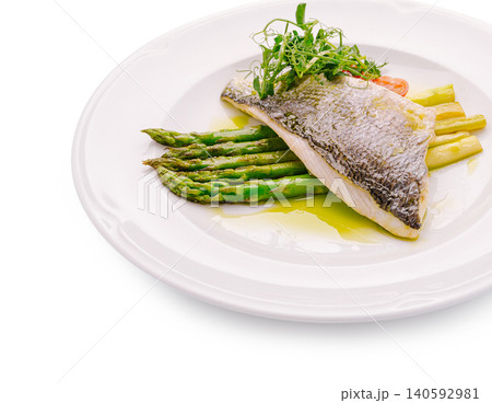 Fried sea bass fillet and asparagus with pea shoots Fried sea bass fillet and asparagus with pea shoots 140592981
