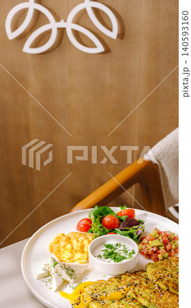 Zucchini fritters breakfast with scrambled eggs cheese Zucchini fritters breakfast with scrambled eggs cheese 140593160