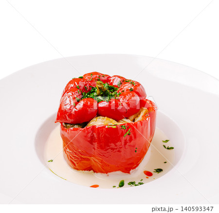 Stuffed red pepper served on a white plate with sauce and garnish Stuffed red pepper served on a white plate with sauce and garnish 140593347