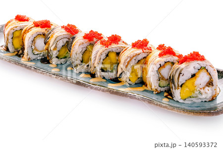 Sushi rolls arranged on a plate with seafood and fruit toppings in a restaurant Sushi rolls arranged on a plate with seafood and fruit toppings in a restaurant 140593372