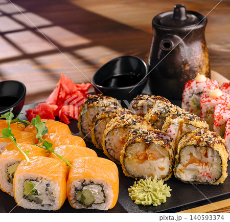Sushi served on a wooden table with sauces and side dishes in a restaurant 140593374