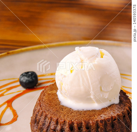 Sticky toffee pudding topped with ice cream 140593378