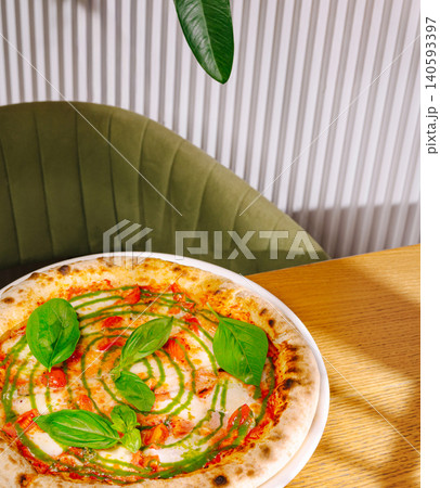 Fresh Margherita pizza with green pesto sauce Fresh Margherita pizza with green pesto sauce 140593397