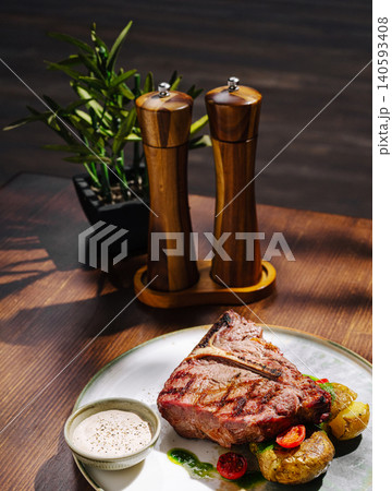 Grilled T-bone steak with roasted potatoes Grilled T-bone steak with roasted potatoes 140593408