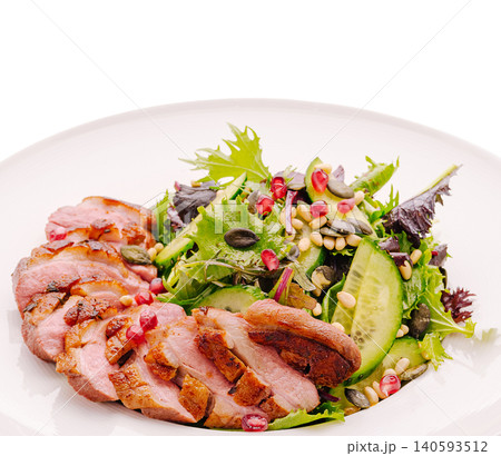 Delicious salad with sliced duck breast and fresh greens on a white plate Delicious salad with sliced duck breast and fresh greens on a white plate 140593512