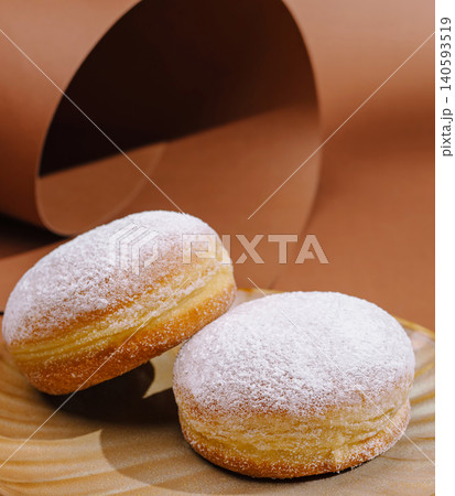 Freshly baked donuts on a wooden plate with a simple background Freshly baked donuts on a wooden plate with a simple background 140593519