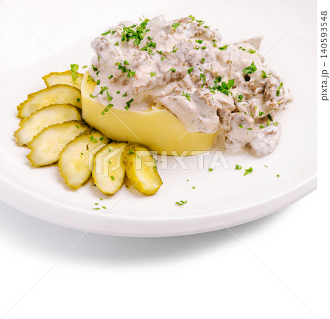 Delicious dish with mashed potatoes, creamy sauce, and pickles served on a plate 140593548