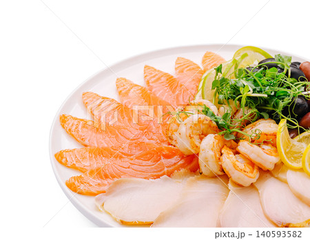 Seafood platter with shrimp, salmon, and lemon slices served on white plate Seafood platter with shrimp, salmon, and lemon slices served on white plate 140593582