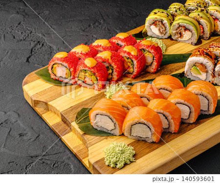 Sushi rolls served on a wooden platter at a restaurant in the evening Sushi rolls served on a wooden platter at a restaurant in the evening 140593601