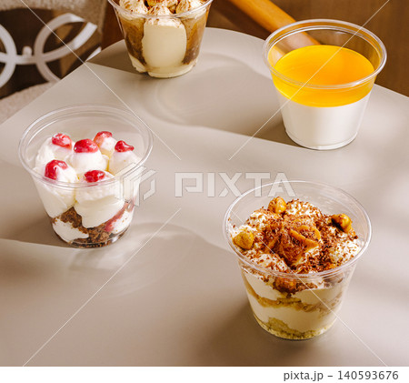 Various dessert cups sit on a table in a cafe during the afternoon Various dessert cups sit on a table in a cafe during the afternoon 140593676