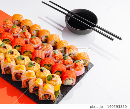 Variety of sushi rolls on a black plate with chopsticks and soy sauce Variety of sushi rolls on a black plate with chopsticks and soy sauce 140593820