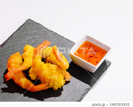 Shrimp served with sauce on a black stone plate in a bright setting Shrimp served with sauce on a black stone plate in a bright setting 140593932