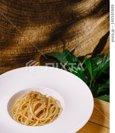 Spaghetti served on white plate with wooden background and green leaves 140593989