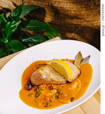 Fresh fish dish served with sauce and bread at a restaurant in the afternoon Fresh fish dish served with sauce and bread at a restaurant in the afternoon 140593990