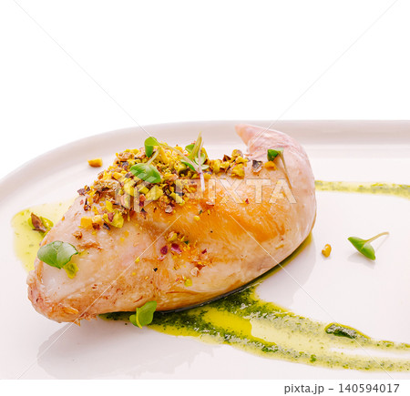 Dish on a white plate with sauce and garnish in a clean setting 140594017
