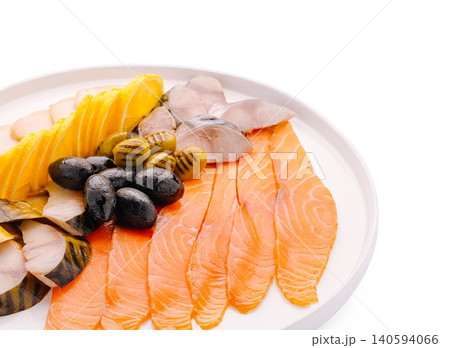 Sliced fish and olives arranged on a white plate for a meal 140594066