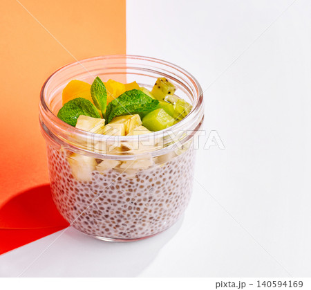 Healthy chia seed pudding with fruits in a glass jar in bright light Healthy chia seed pudding with fruits in a glass jar in bright light 140594169