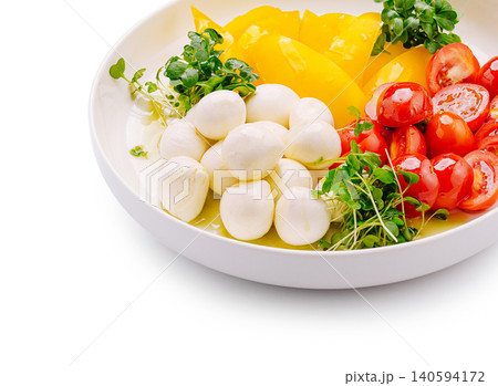 Fresh mozzarella balls with sliced tomatoes and yellow peppers on a plate Fresh mozzarella balls with sliced tomatoes and yellow peppers on a plate 140594172