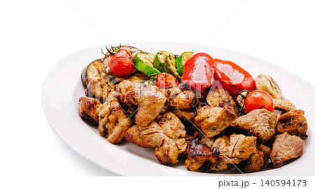 Grilled meat and vegetables served on white plate at outdoor barbecue Grilled meat and vegetables served on white plate at outdoor barbecue 140594173